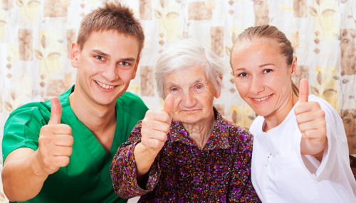 Seniorin mit Pflegekräften